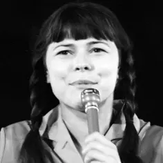 Karin Stanek z mikrofonem, warkocze i charakterystyczna grzywka. Jej niezapomniane utwory wciąż brzmią w sercach fanów.