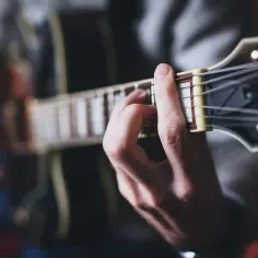Dłoń grająca akord na gitarze. Może to być początek grania maanam piosenki alfabetycznie.